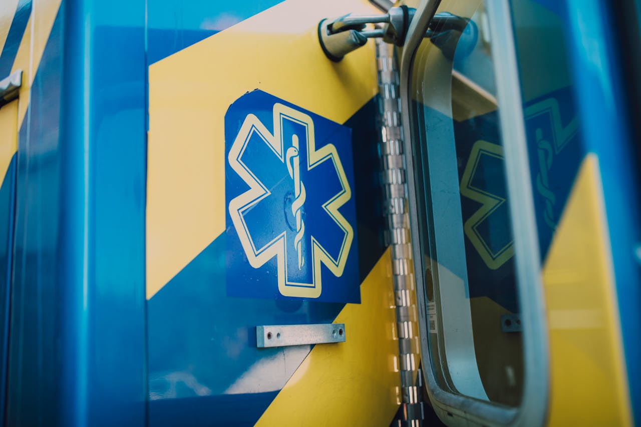 Vibrant blue and yellow medic symbol on an ambulance door, representing emergency medical services.