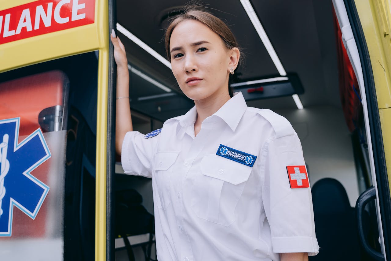 about-01 Young paramedic stands confidently by an ambulance, ready for emergency response.